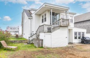 a white house with a balcony and a chair at The Granite Harbor in Wells