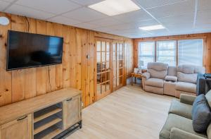sala de estar con TV de pantalla plana en una pared de madera en The Granite Harbor, en Wells