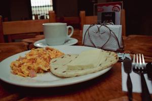 a plate of food on a table with a cup of coffee at Hotel Boutique Sagrado Corazon in Abejorral