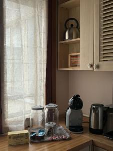 a kitchen counter with two glass jars and a window at Este Stay in Este +21 photos