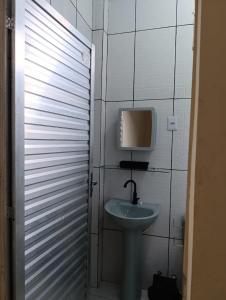 a bathroom with a sink and a tv on the wall at Suite das Mangueiras I in Soure +40 photos