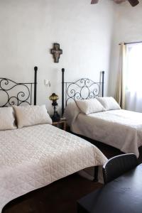una camera con due letti e una croce sul muro di Hotel Boutique Canto De Piedra a Tamasopo