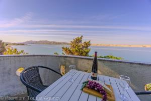 a table with a bottle of wine and grapes on it at Galeb in Kustići
