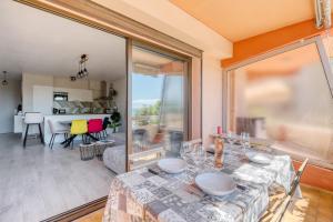 a dining room with a table and a large window at Le Diamant du Soleil Sea View New City Center & Parking in Le Lavandou