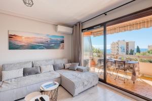 a living room with a couch and a large window at Le Diamant du Soleil Sea View New City Center & Parking in Le Lavandou