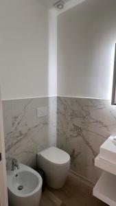 a bathroom with a white toilet and a sink at Rosso Conero - Le Grotte Rooms & Apartments in Camerano +34 photos