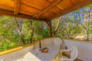 a porch with a table and chairs and trees at Galeb in Kustići +70 photos