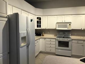 a kitchen with white cabinets and a refrigerator at 119 Z2b VILLAGE LA ZAMORA by REMAX Premier in The Villages
