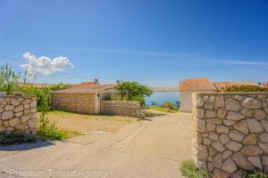 a house with a stone fence and a stone wall at Galeb in Kustići
