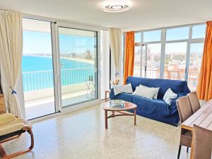 salon z niebieską kanapą i dużymi oknami w obiekcie Tahiti - Frente al Mar - Gran Terraza - Parking Gratis w mieście El Campello
