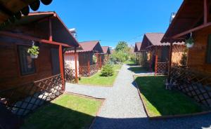 a walkway between two houses with grass between them at Casute ,, la dani" in Corbu