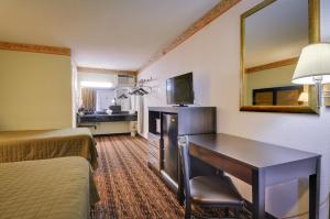 a hotel room with two beds and a desk and a mirror at Vagabond Inn Sunnyvale in Sunnyvale