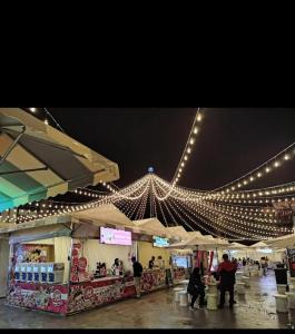 a market with lights and people standing around a store at KhaiLa Emerald Apartment Cameron Highlands in Brinchang +13 photos