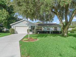 a house with a tree and a driveway at 1632 Z1 Village of Orange Blossom Gardens by REMAX Premier in The Villages