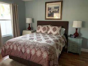1 dormitorio con 1 cama y 2 mesas con lámparas en 1413U Z3b VILLAGE OF MALLORY SQUARE by REMAX Premier, en The Villages
