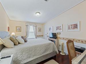 a bedroom with a bed and a desk and a window at 1705 Z1 Village of Orange Blossom Gardens by REMAX Premier in The Villages