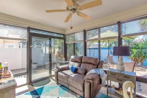 Una sala de estar con un sofá y grandes ventanales. en 2332 Z3B VILLAGE OF HADLEY by REMAX Premier, en The Villages
