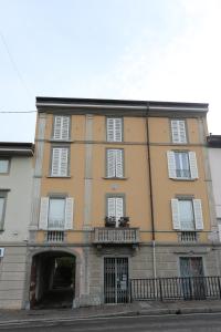 a large yellow building with a balcony on a street at New Ulivo Apartment 2 in Seriate +7 photos