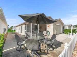 a patio with a table and chairs and an umbrella at 3496 Z2A VILLAGE OF SUMMERHILL by REMAX Premier in The Villages