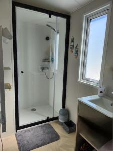 a bathroom with a shower and a sink at Cottage dans un camping 4 étoiles in La Teste-de-Buch