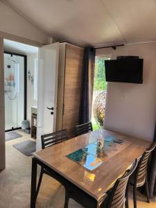 a dining room with a wooden table and chairs at Cottage dans un camping 4 étoiles in La Teste-de-Buch