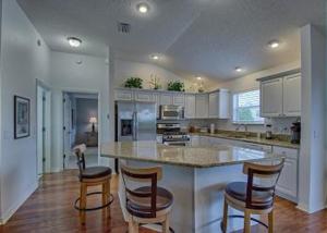 una cocina con una isla grande con 2 taburetes en 780 Z3a VILLAGE OF LARGO by REMAX Premier, en The Villages