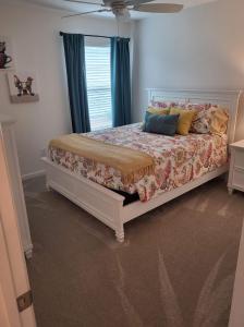 a bedroom with a white bed with a window at 3 Bedroom 2 Bath Designer in The Villages +11 photos