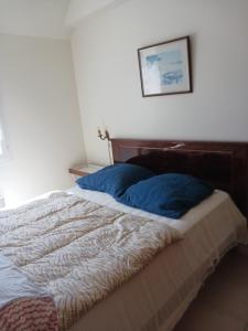 Un dormitorio con una cama con almohadas azules. en maison 6 personnes FREHEL, en Fréhel