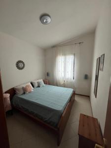 a bedroom with a bed with a blue comforter at Casa Giuli in Villasimius