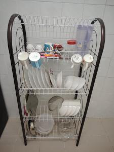 a wire rack with dishes and other items on it at 22 Homestay Tenom in Tenom +9 photos