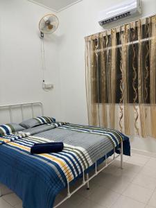 a bedroom with a bed with a blue blanket at 22 Homestay Tenom in Tenom
