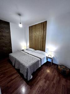 a bedroom with a large bed with a wooden headboard at La estación in Villafranca del Bierzo