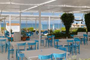 a group of tables and chairs with the ocean in the background at Residence Le 4 Stagioni in Menfi
