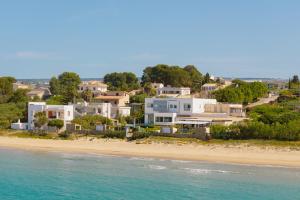 a group of houses on a beach next to the water at Residence Le 4 Stagioni in Menfi