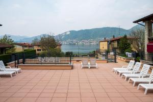 a group of white chairs sitting on top of a patio at Bellavista Relax Iseo Lake House in Paratico