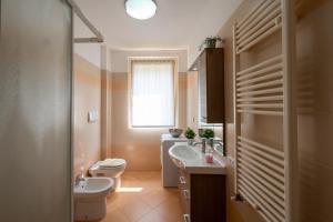 a bathroom with a sink and a toilet and a window at Bellavista Relax Iseo Lake House in Paratico +50 photos