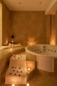 スースにあるSousse Pearl Marriott Resort & Spaのバスタブとバラの模様が描かれたバスマットを備えたバスルーム