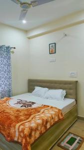 a bedroom with a bed with a comforter on it at Ganga Kinaare in Uttarkāshi