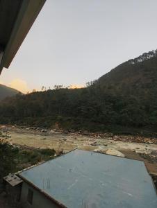 a view of a body of water with a mountain at Ganga Kinaare in Uttarkāshi