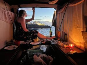 a woman sitting in a boat looking out the window at Vintage Camper Van Explore Driving Mallorca - full equip in Palma de Mallorca