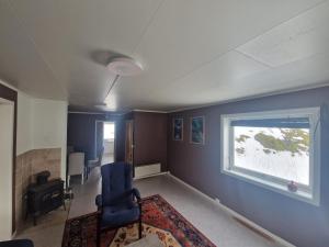 a living room with a chair and a window at Gamle Fiskarheimen i Sund in Sund