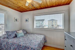 a bedroom with a bed and two windows at 2003 N Shore Drive - Sunbeams Ocean Dreams in West Onslow Beach