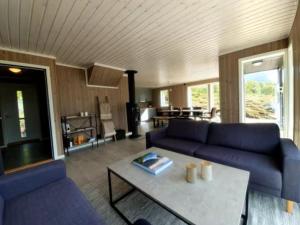 a living room with a blue couch and a table at Explorers Cabin Lofoten in Offersøya
