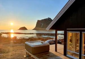 a bath tub on a deck with a view of the ocean at Explorers Cabin Lofoten in Offersøya