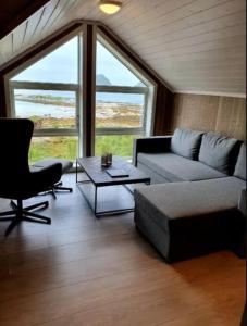a living room with a couch and a table at Explorers Cabin Lofoten in Offersøya