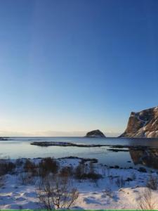 a view of a body of water with snow at Explorers Cabin Lofoten in Offersøya