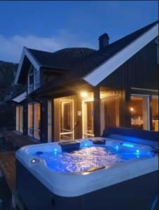 a large hot tub in front of a house at Explorers Cabin Lofoten in Offersøya
