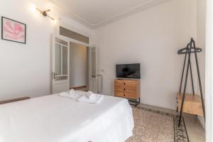 a bedroom with a white bed and a television at Elegant Apartments Palumbo in Rome