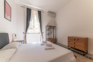 a bedroom with a white bed and a dresser and a window at Elegant Apartments Palumbo in Rome