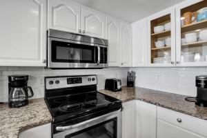 a kitchen with a stove and a microwave at St Regis 1505 in Chadwick Acres